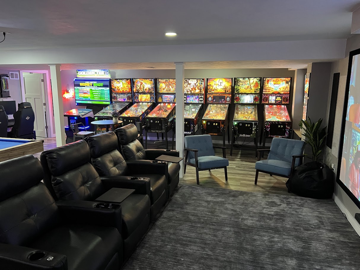 Our main line up of Stern Pinballs, Rush, Jurassic Park, Mandalorian, Star Wars, Black Knight, Guardians of the Galaxy, and Godzilla, next to a PGA Tour Golden Tee.